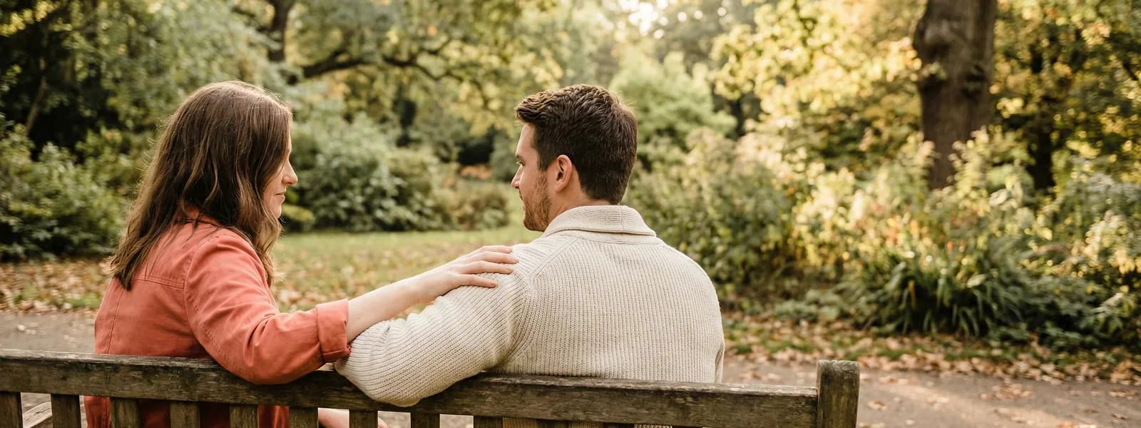 Couple sitting together on a park bench, supporting each other
