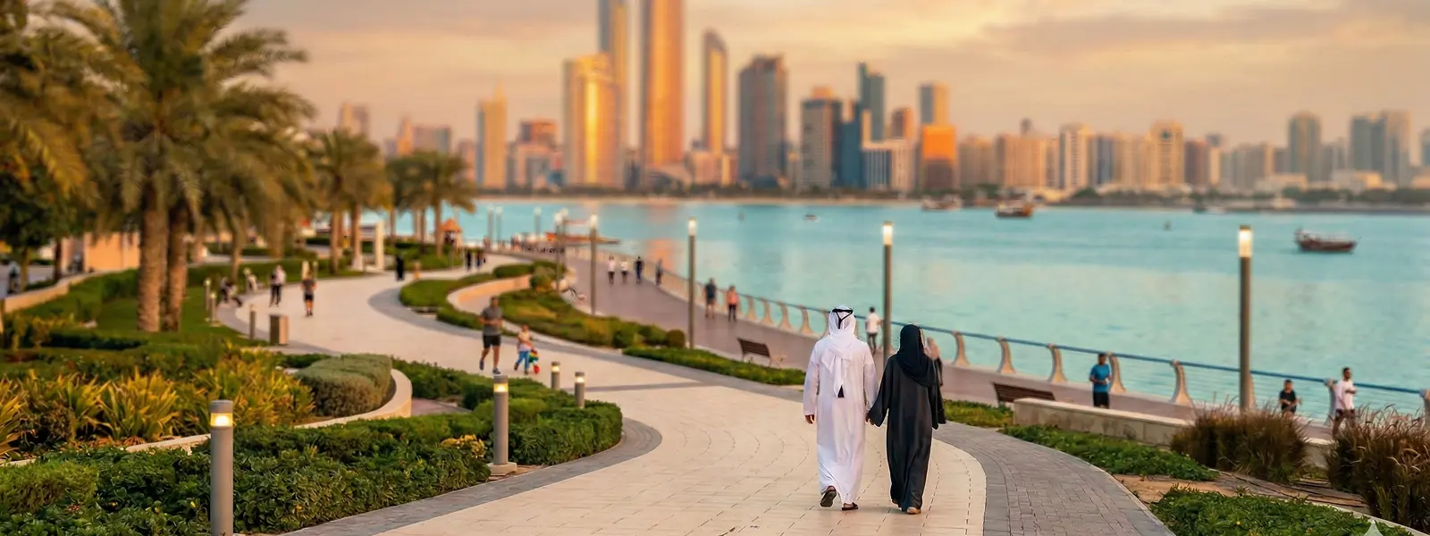 South Asian couple walking along modern pathway in Abu Dhabi at golden hour